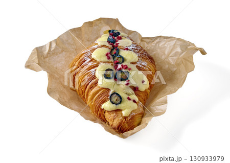 sweet croissant with blueberries on parchment paper isolated on white background sweet croissant with blueberries on parchment paper isolated on white background 130933979