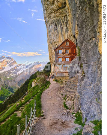 Lodging nestled against a mountain cliff with panoramic views of the Swiss Alps 130934472