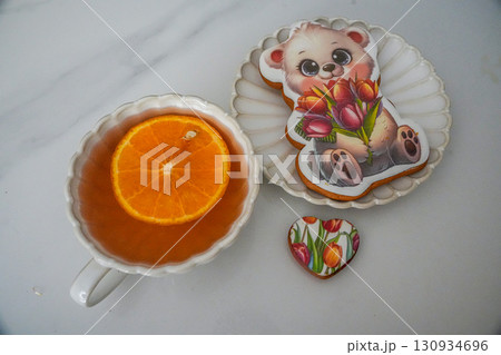 Orange tea with bear and heart-shaped cookies on plate. High quality photo Orange tea with bear and heart-shaped cookies on plate. High quality photo 130934696