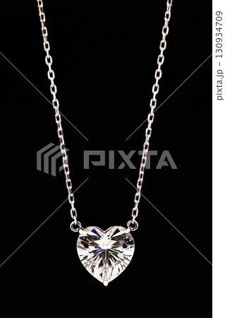 A heart shaped pendant with a chain is displayed in a black box 130934709