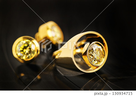 A gold ring with a yellow stone in the center 130934715
