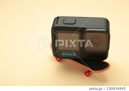 Ukraine, Mykolaiv - September 1, 2025: GoPro 13 action camera Black on skateboard on beige background. Ukraine, Mykolaiv - September 1, 2025: GoPro 13 action camera Black on skateboard on beige background. 130934845