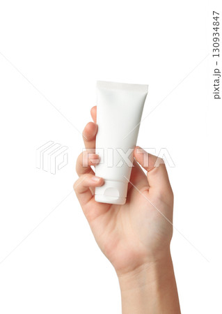 Hand holding blank white plastic tube isolated on white background. Cosmetic beauty product branding mockup. Vertical photo 130934847