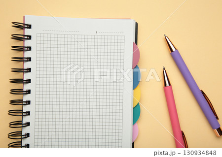 Notebook with colorful pens on beige background. 130934848