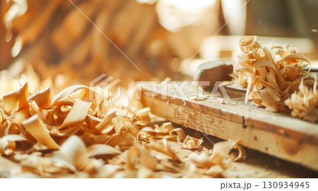 Wood shavings scattered on workbench in warm light, capturing essence of craftsmanship and woodworking. Concept emphasizes handmade creations, artisanal skills, and beauty of sustainable craftsmanship Wood shavings scattered on workbench in warm light, capturing essence of craftsmanship and woodworking. Concept emphasizes handmade creations, artisanal skills, and beauty of sustainable craftsmanship 130934945