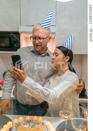 Couple Birthday Celebration Selfie Kitchen: Happy couple takes selfie with birthday cake during kitchen party. 130935083