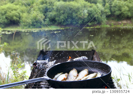 Cooking fresh fish catch. Frying pieces of fish. Delicious dish fried over fire 130935724