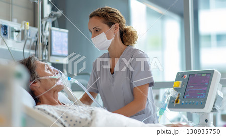 A dedicated nurse wearing protective mask attentively checks on a senior patient who is in bed, using ventilator. Scene portrays compassionate medical care, importance of professional health services 130935750