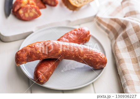 Sliced smoked sausage on plate. 130936227