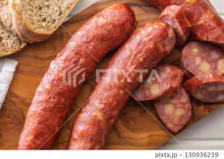 Sliced smoked sausage on cutting board. 130936239