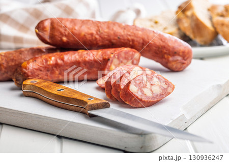 Sliced smoked sausage on cutting board. Sliced smoked sausage on cutting board. 130936247