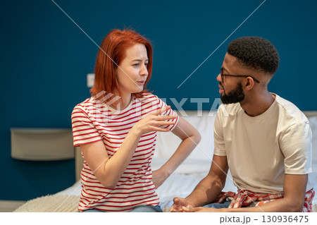 Young interracial couple husband and wife sit on bed at home discussing intimacy issues Young interracial couple husband and wife sit on bed at home discussing intimacy issues 130936475
