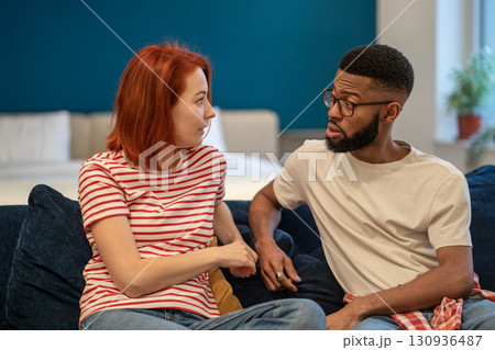 Young interracial couple husband and wife sit on bed at home discussing intimacy issues Young interracial couple husband and wife sit on bed at home discussing intimacy issues 130936487