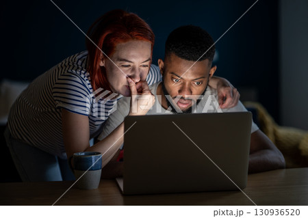 Multiracial man woman family looking at laptop screen buying online choosing goods in marketplace. 130936520