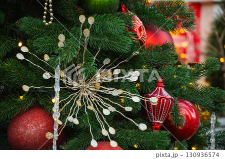 Christmas tree with creative silver decorations ball and lights garland. Xmas card. Close up. Winter holiday spirit. Outdoors. Christmas tree with creative silver decorations ball and lights garland. Xmas card. Close up. Winter holiday spirit. Outdoors. 130936574