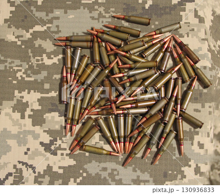 Cartridges for Kalashnikov assault rifle. War Concept. Heap of billets Cartridges for Kalashnikov assault rifle. War Concept. Heap of billets 130936833
