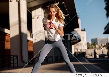 Woman jogging outdoors in a modern urban environment during golden hour Woman jogging outdoors in a modern urban environment during golden hour 130937708