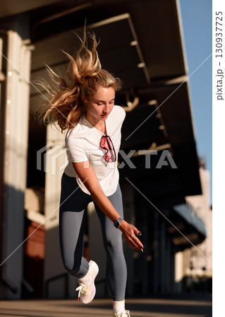Young woman enjoying an outdoor workout session in the warm sunlight Young woman enjoying an outdoor workout session in the warm sunlight 130937725
