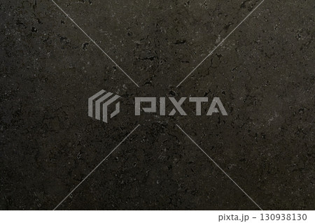 Dark textured stone surface highlighting natural patterns and subtle variations in tones from 130938130