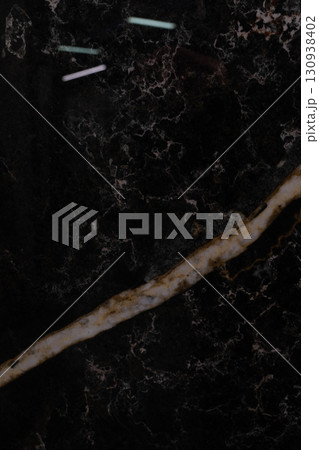 Dark marble surface with contrasting light veins and textured patterns for elegant interior design Dark marble surface with contrasting light veins and textured patterns for elegant interior design 130938402