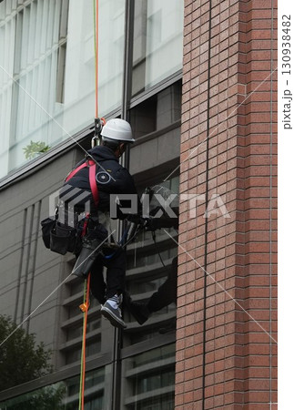 命綱でビルの窓ガラスを清掃する男性 130938482