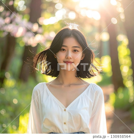 木漏れ日の中で微笑む女性、自然な美しさと爽やかな雰囲気を表現したポートレート 130938564