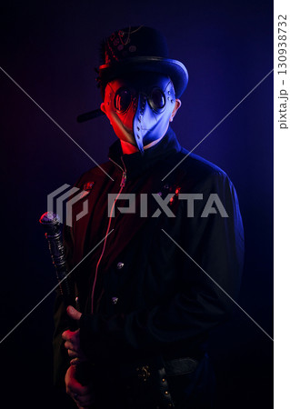 Steampunk plague doctor costume for Halloween. Plague doctor with crow-like mask on black background 130938732