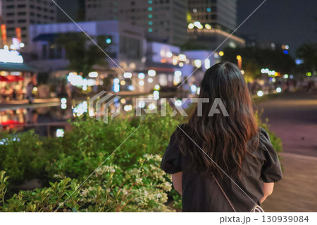 夜の街並みを眺める女性の後ろ姿 夜の街並みを眺める女性の後ろ姿 130939084