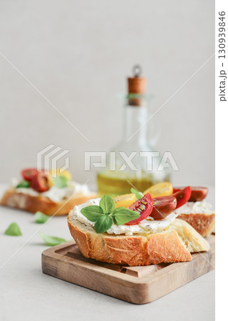 Bruschetta sandwiches with tomatoes, cream cheese, olive oil and basil on a plate 130939846