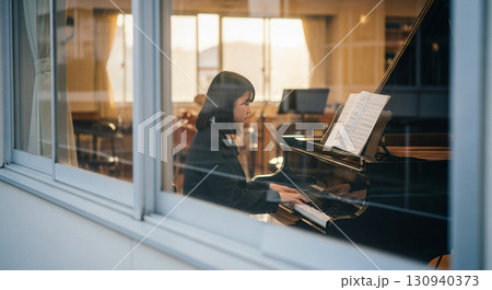 望遠レンズで校舎外から窓越しに撮影した、音楽室でピアノを弾く女子高校生 130940373
