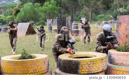 Couple of paintball players playing paintboll outdoors Couple of paintball players playing paintboll outdoors 130940650