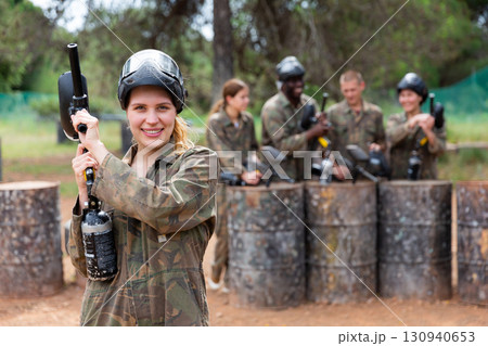 Portrait of girl in camouflage on paintball field 130940653