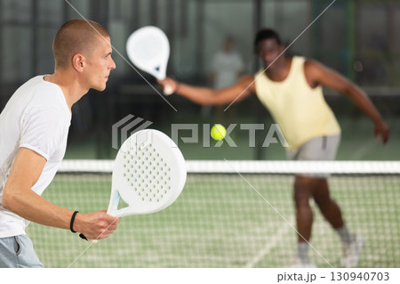 Male player ready to hits the ball while playing padel Male player ready to hits the ball while playing padel 130940703