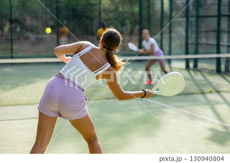 European woman tennis player in padel tennis playing on the outdoor court European woman tennis player in padel tennis playing on the outdoor court 130940804