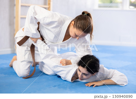 Two women training judo techniques in studio 130940890