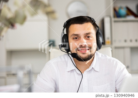 Portrait of positive man office worker wearing headset 130940946