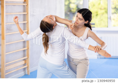 Active woman with professional female trainer are training captures on self-defense course in gym Active woman with professional female trainer are training captures on self-defense course in gym 130940950