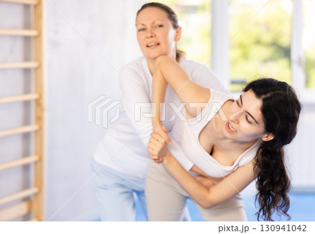 Two women training self-defense techniques in studio 130941042