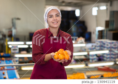 Smiling young girl working on mandarins sorting factory 130941119