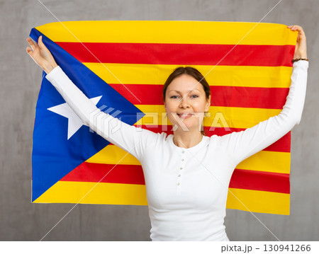 Smiling woman posing with Catalan Estelada in studio 130941266