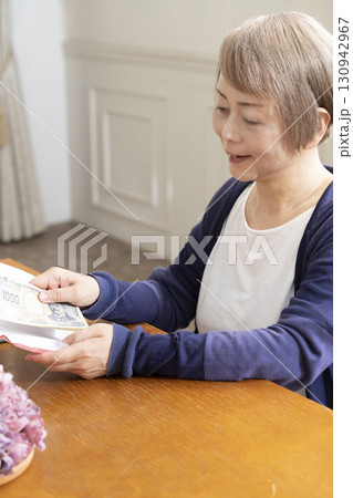 ご祝儀袋に筆ペンで表書きをするシニア女性 ご祝儀袋に筆ペンで表書きをするシニア女性 130942967