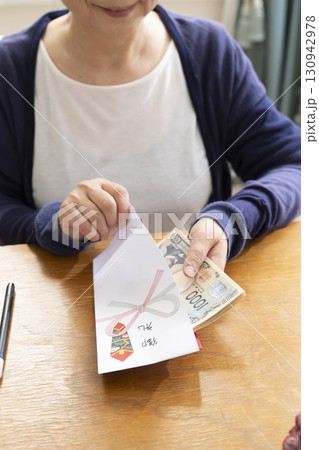 ご祝儀袋に筆ペンで表書きをするシニア女性 ご祝儀袋に筆ペンで表書きをするシニア女性 130942978