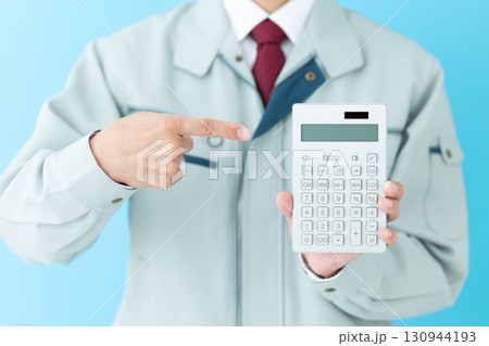 電卓を指差す作業着姿のミドル男性ビジネスマン 130944193