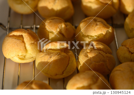 Perfectly baked golden pastries cooling on a rack in a cozy kitchen during  130945124
