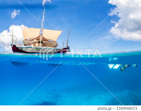 カタマランヨットのダイビングクルーズ船の半水面撮影。美しいサンゴ礁と熱帯魚の群れ。 沖縄県島尻郡慶良 130948015