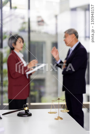 Legal professionals discussion scales of justice gavel blurred Asian adults meeting office law firm consultation courtroom concept Legal professionals discussion scales of justice gavel blurred Asian adults meeting office law firm consultation courtroom concept 130948157