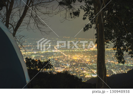 landscape and travel concept with camping tent on mountain and light of city background 130948938