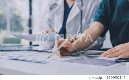 Medical team meeting analyzing blood test results in hospital laboratory. Doctors and scientists in lab coats are having a discussion about blood test result, holding test tubes and taking notes. Medical team meeting analyzing blood test results in hospital laboratory. Doctors and scientists in lab coats are having a discussion about blood test result, holding test tubes and taking notes. 130950145