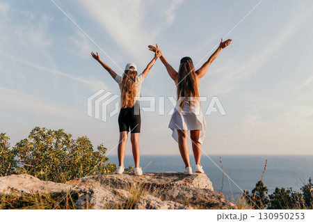 Two Women Standing On A Clifftop 130950253