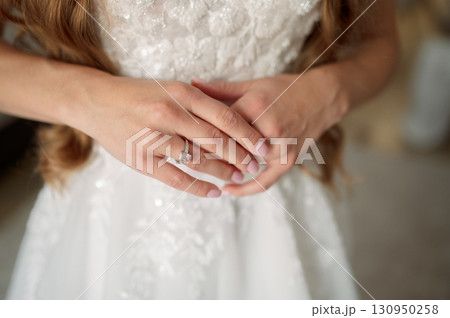 Bride wearing a stunning white wedding dress, proudly showcasing a dazzling diamond engagement ring, and love commitment symbolizing 130950258